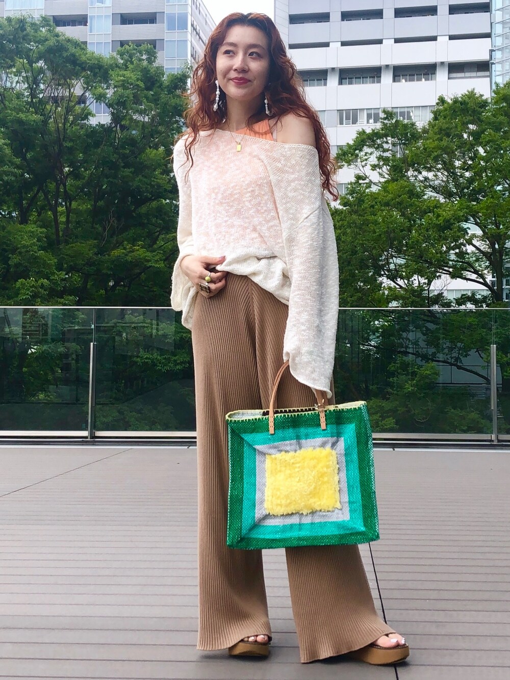 ホワイト系のニット/セーター、ベージュ系のその他パンツ、グリーン系のトートバッグを着用したレディースの夏コーディネートの1枚目の写真