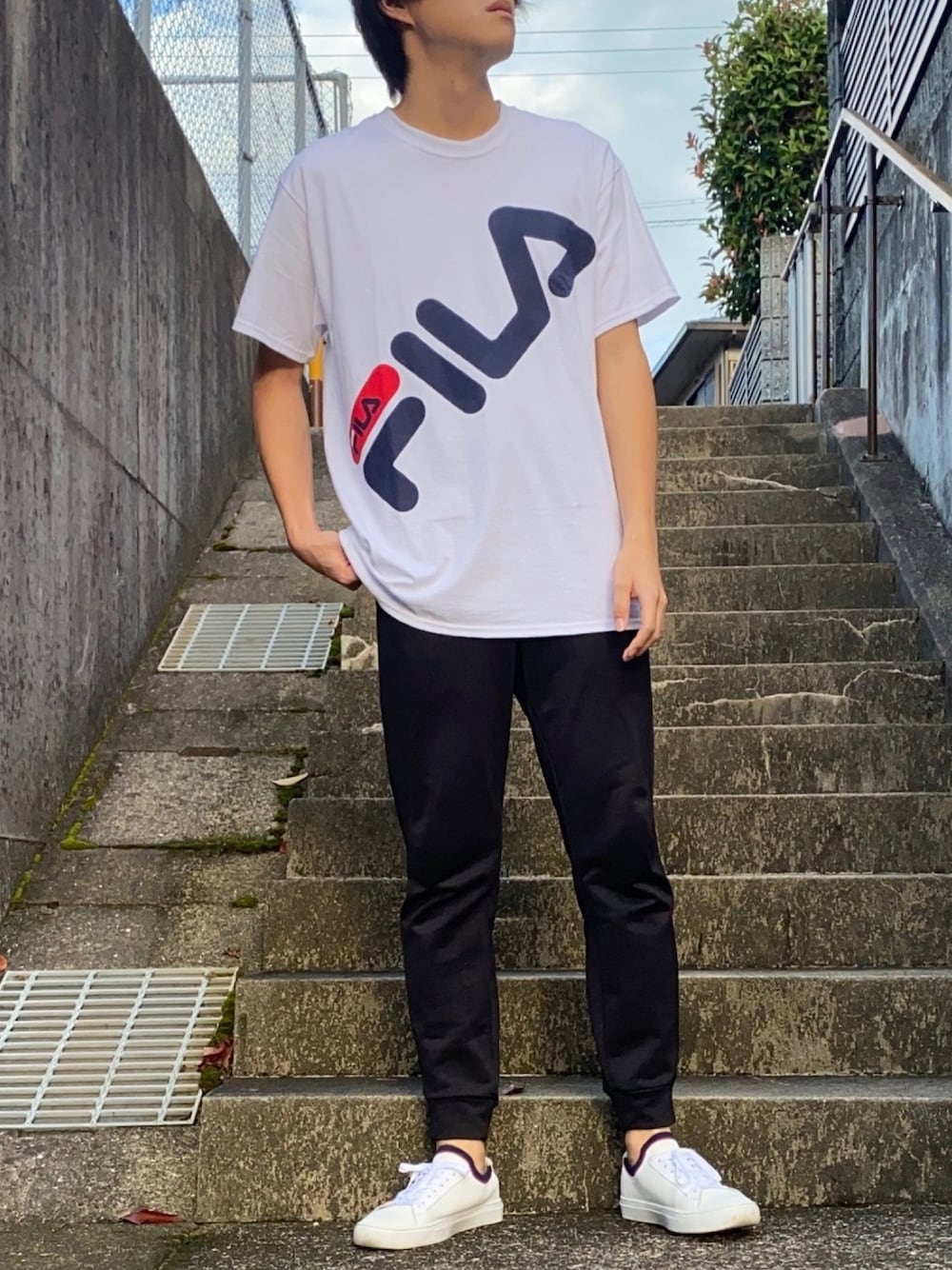 ホワイト系のTシャツ/カットソー、ブラック系のその他パンツ、ホワイト系のスニーカーを着用したメンズの秋コーディネートの1枚目の写真