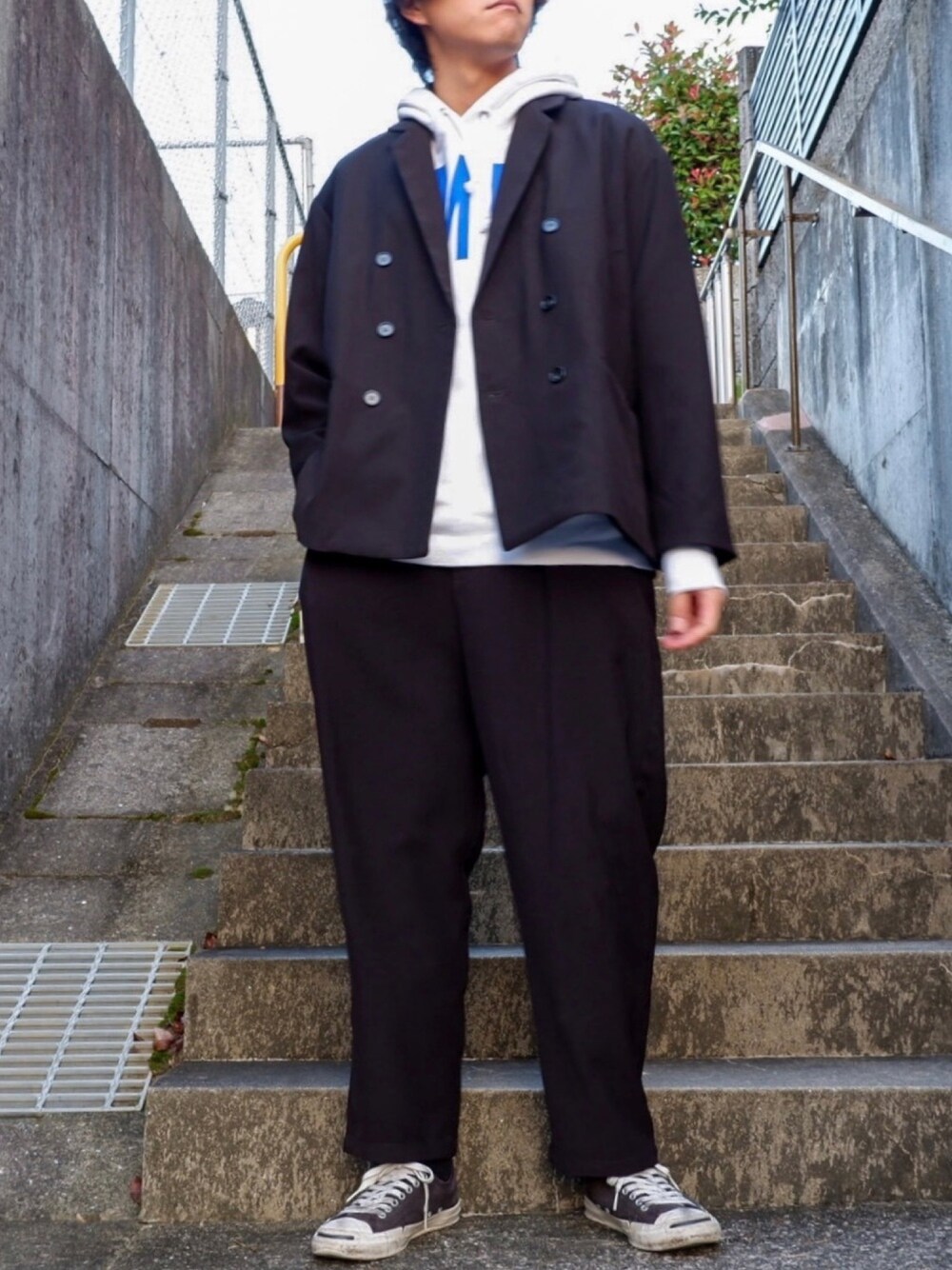 グレー系のパーカー、ブラック系のテーラードジャケット、ブラック系のその他パンツを着用したメンズの秋コーディネートの1枚目の写真