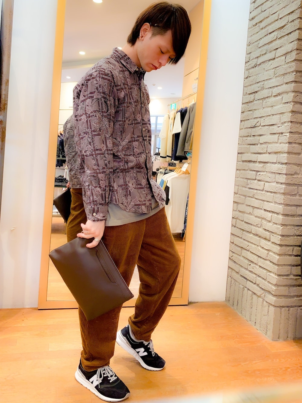 ブラック系のスニーカー、イエロー系のその他パンツ、ブラウン系のクラッチバッグを着用したメンズの秋コーディネートの1枚目の写真