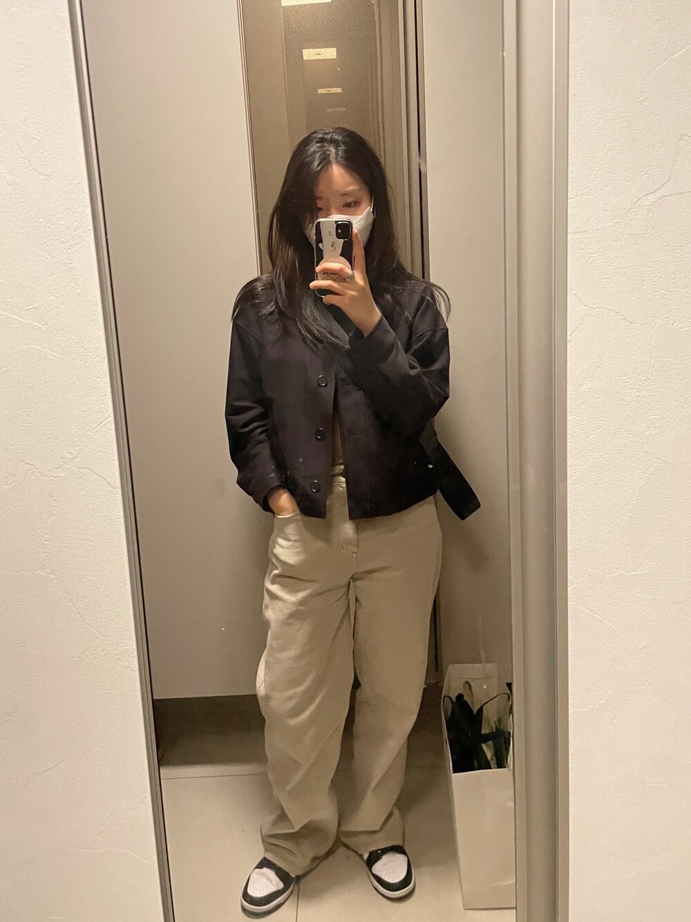 ブラック系のジャケット/アウター、シルバー系のショルダーバッグ、ベージュ系のチノパンツを着用したレディースの春コーディネートの1枚目の写真