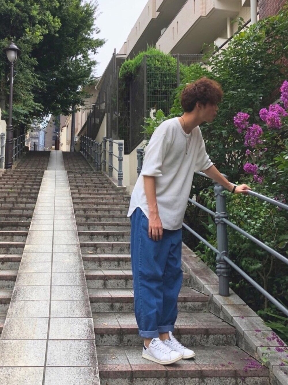 ブルー系のデニムパンツ、ホワイト系のスニーカー、ホワイト系のTシャツ/カットソーを着用したメンズの夏コーディネートの1枚目の写真
