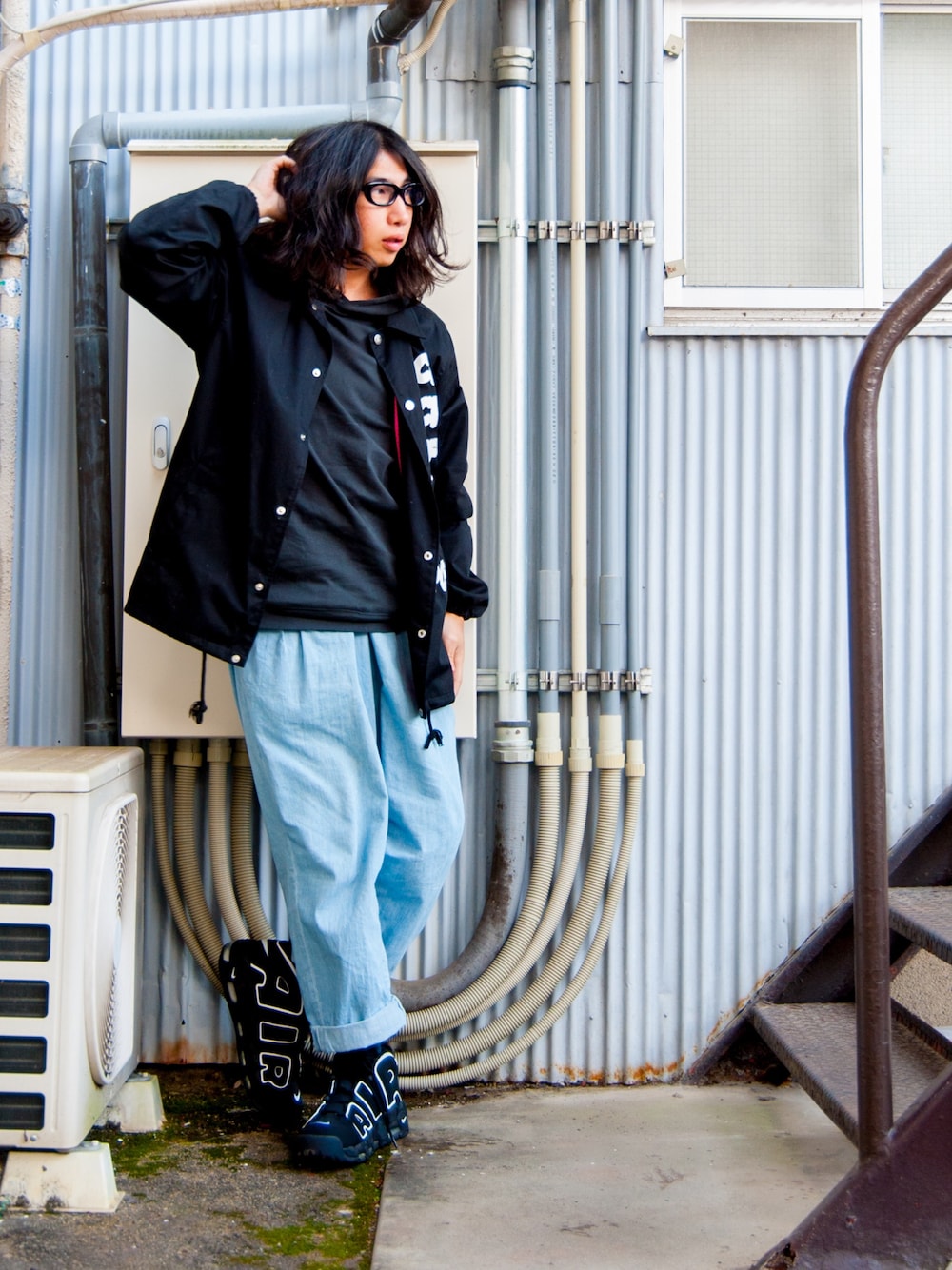 ブラック系のブルゾン、グレー系のパーカー、ブルー系のデニムパンツを着用したメンズの冬コーディネートの1枚目の写真