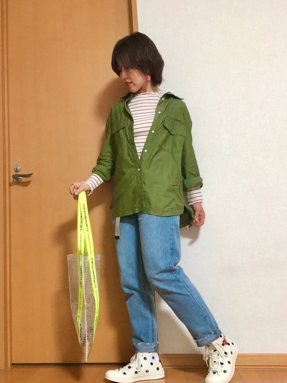グリーン系のシャツ/ブラウス、レッド系のTシャツ/カットソー、ブルー系のデニムパンツを着用したレディースの春コーディネートの1枚目の写真