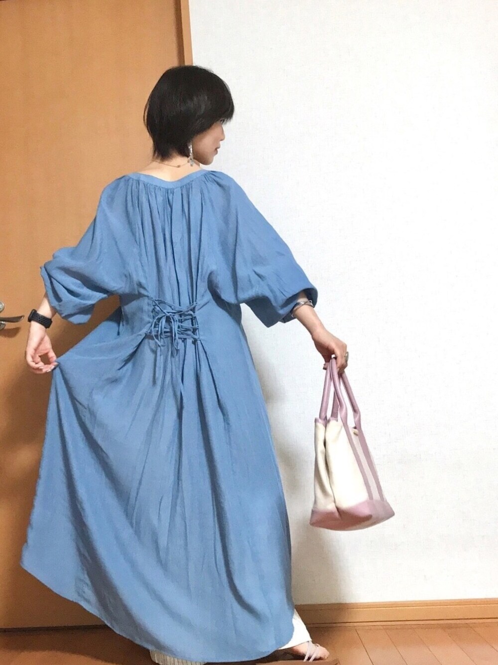 ブルー系のシャツワンピース、ピンク系のトートバッグ、ピンク系のサンダルを着用したレディースの夏コーディネートの1枚目の写真