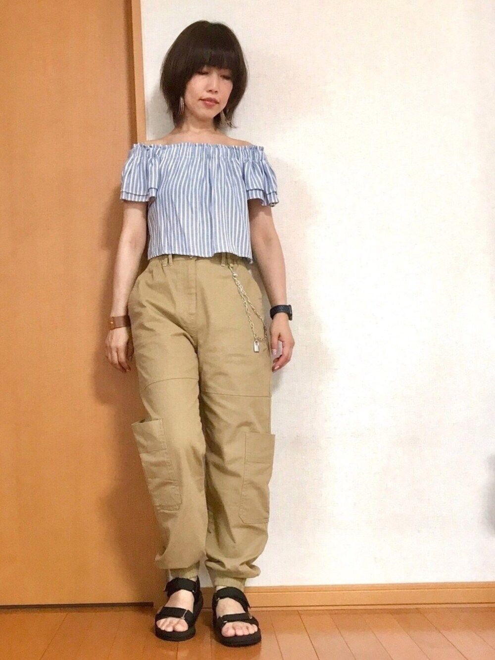 ベージュ系のカーゴパンツ、ブラック系のサンダル、ベージュ系のカーゴパンツを着用したレディースの夏コーディネートの1枚目の写真