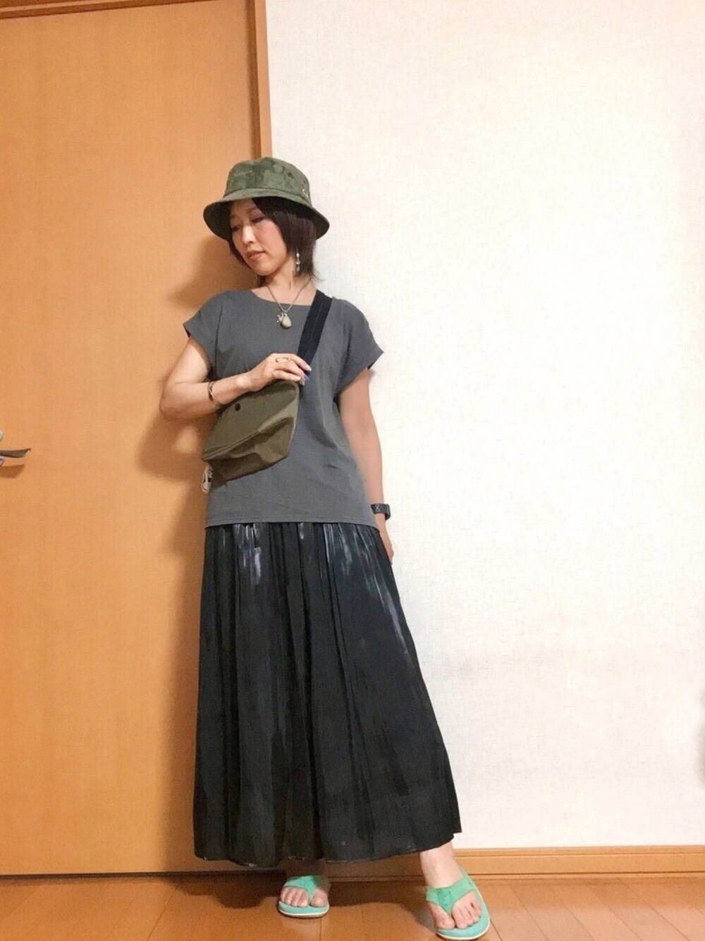 グレー系のTシャツ/カットソー、グリーン系のショルダーバッグ、ブラック系のスカートを着用したレディースの夏コーディネートの1枚目の写真