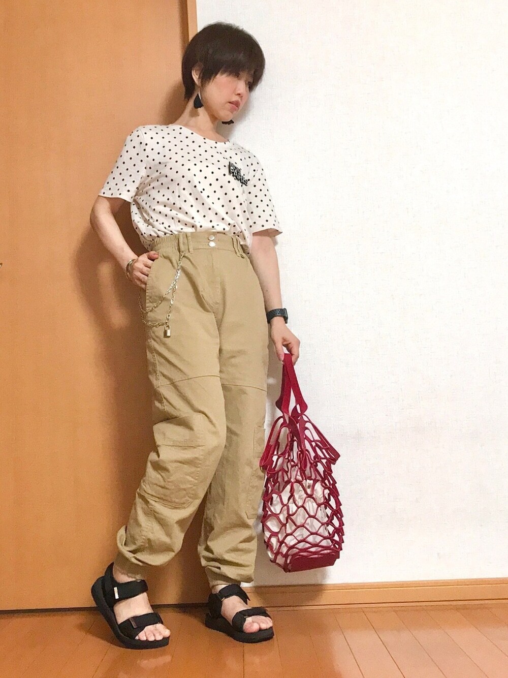 ベージュ系のカーゴパンツ、ブラック系のサンダル、レッド系のトートバッグを着用したレディースの秋コーディネートの1枚目の写真