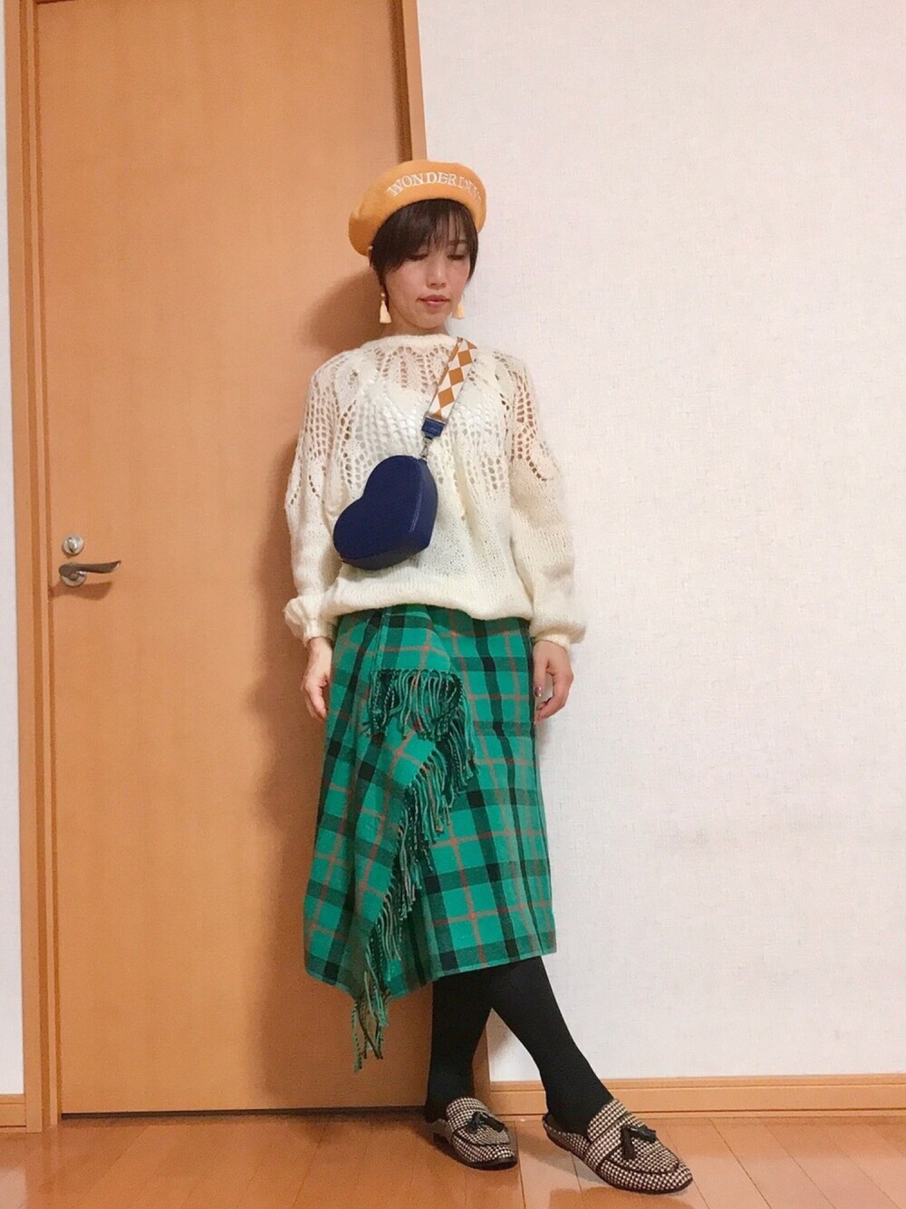 グリーン系のスカート、ブルー系のショルダーバッグ、ベージュ系のドレスシューズを着用したレディースの秋コーディネートの1枚目の写真