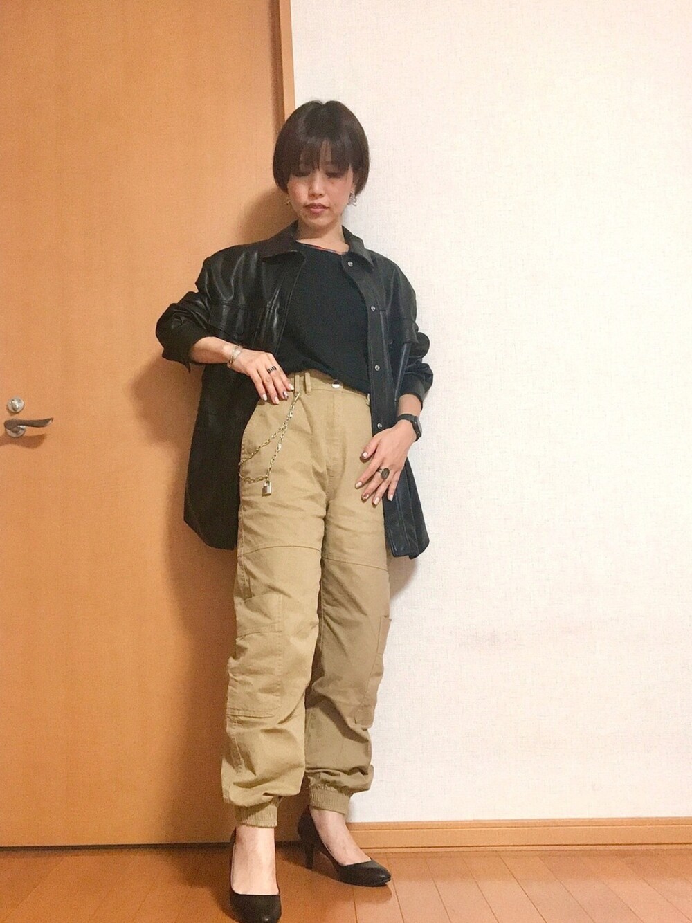 ベージュ系のカーゴパンツ、ブラック系のパンプス、ブラック系のTシャツ/カットソーを着用したレディースの冬コーディネートの1枚目の写真