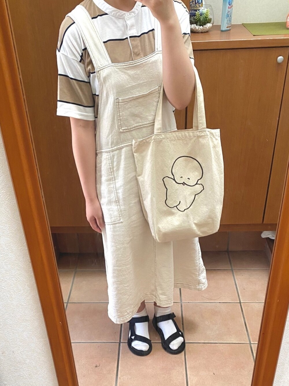 ホワイト系のジャンパースカート、ベージュ系のTシャツ/カットソー、ホワイト系のトートバッグを着用したレディースの夏コーディネートの1枚目の写真