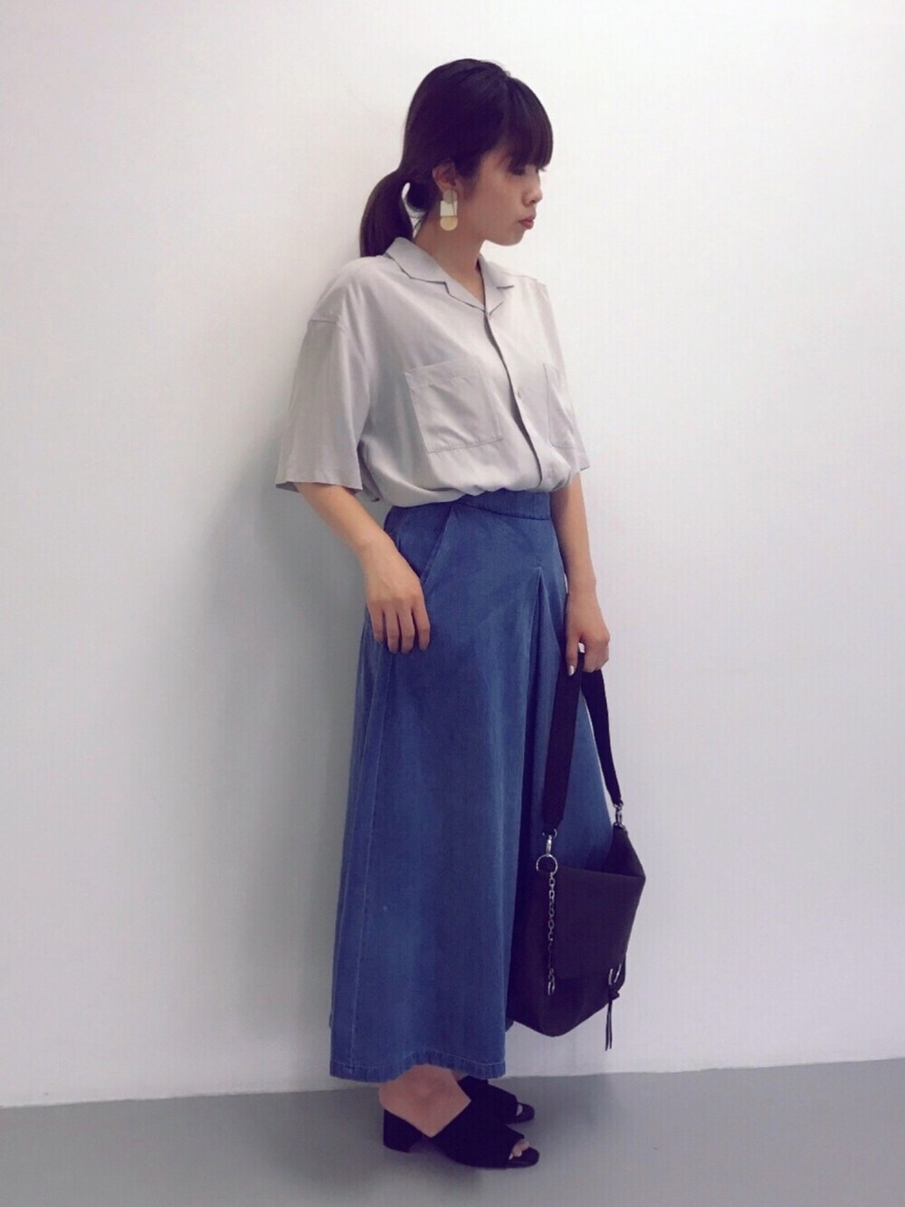 グレー系のシャツ/ブラウス、ブルー系のデニムパンツ、ブラック系のショルダーバッグを着用したレディースの夏コーディネートの1枚目の写真