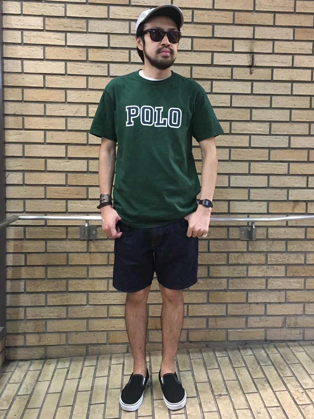 ブラック系のスニーカー、ブルー系のデニムパンツ、グリーン系のTシャツ/カットソーを着用したメンズの夏コーディネートの1枚目の写真