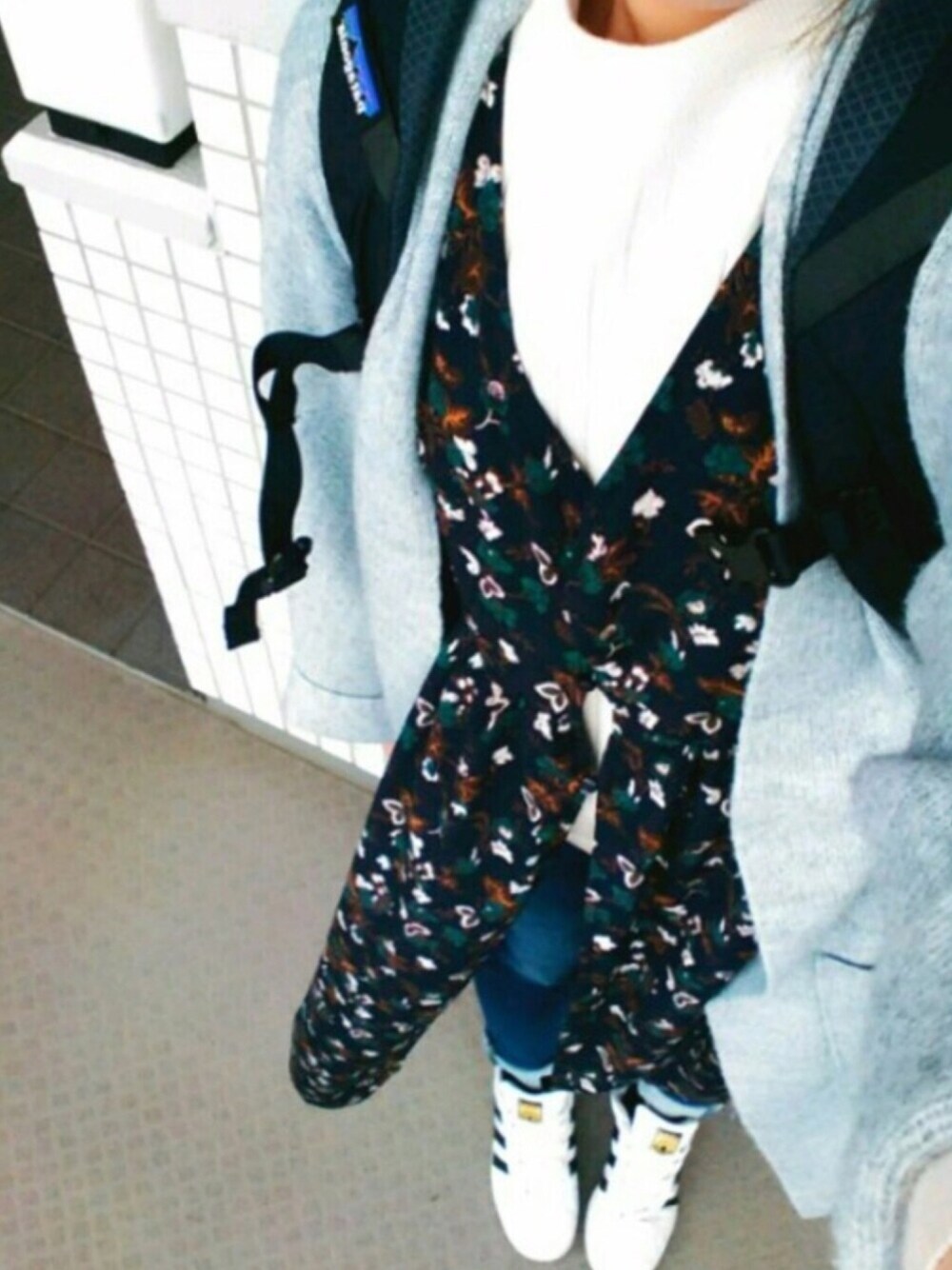 ブラック系のバックパック/リュック、ブルー系のデニムパンツ、ホワイト系のスニーカーを着用したレディースの冬コーディネートの1枚目の写真