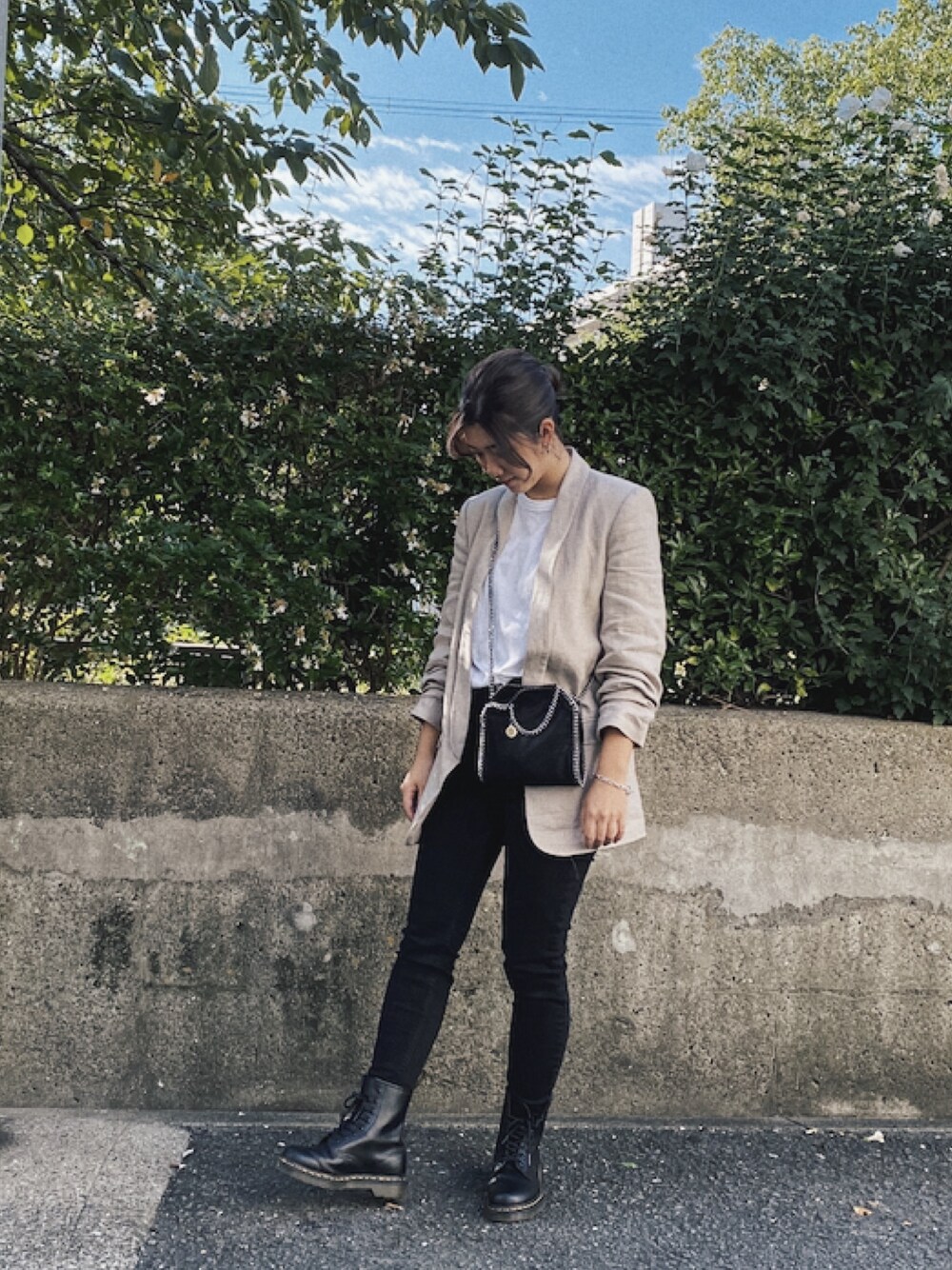 ベージュ系のジャケット/アウター、ホワイト系のトップス、ブラック系のショルダーバッグを着用したレディースの秋コーディネートの1枚目の写真