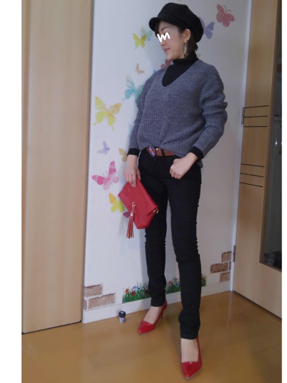 ブラック系のトップス、ブラック系のデニムパンツ、レッド系のショルダーバッグを着用したレディースの冬コーディネートの1枚目の写真