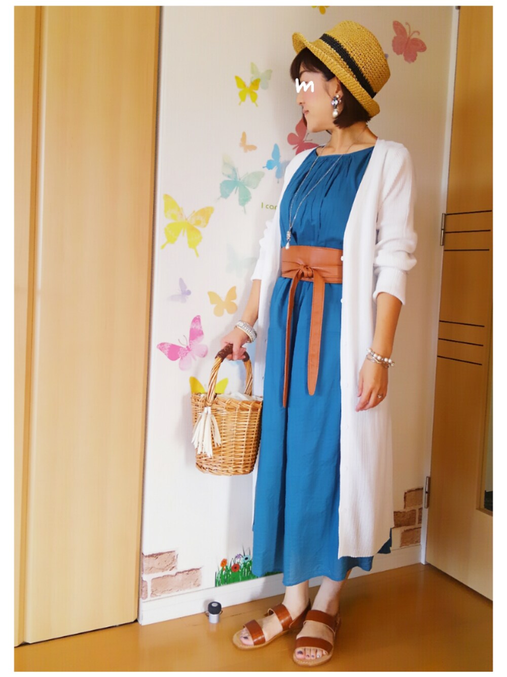 ブルー系のワンピース、ベージュ系のかごバッグ、ブラウン系のサンダルを着用したレディースの夏コーディネートの1枚目の写真