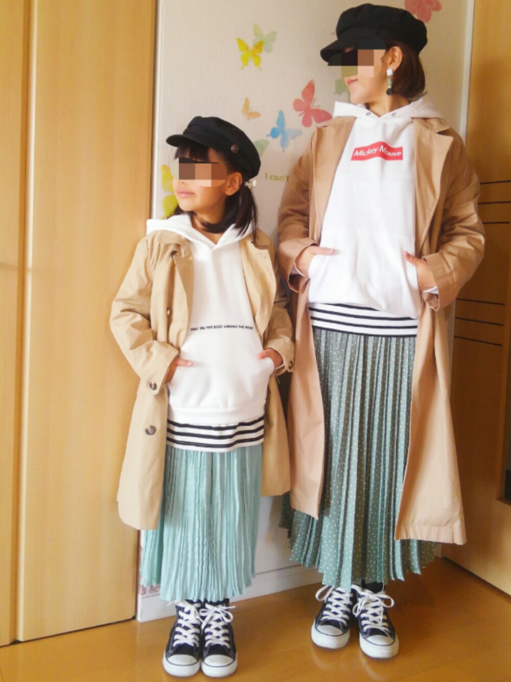 グリーン系のスカート、ベージュ系のトレンチコート、ホワイト系のパーカーを着用したキッズの春コーディネートの1枚目の写真