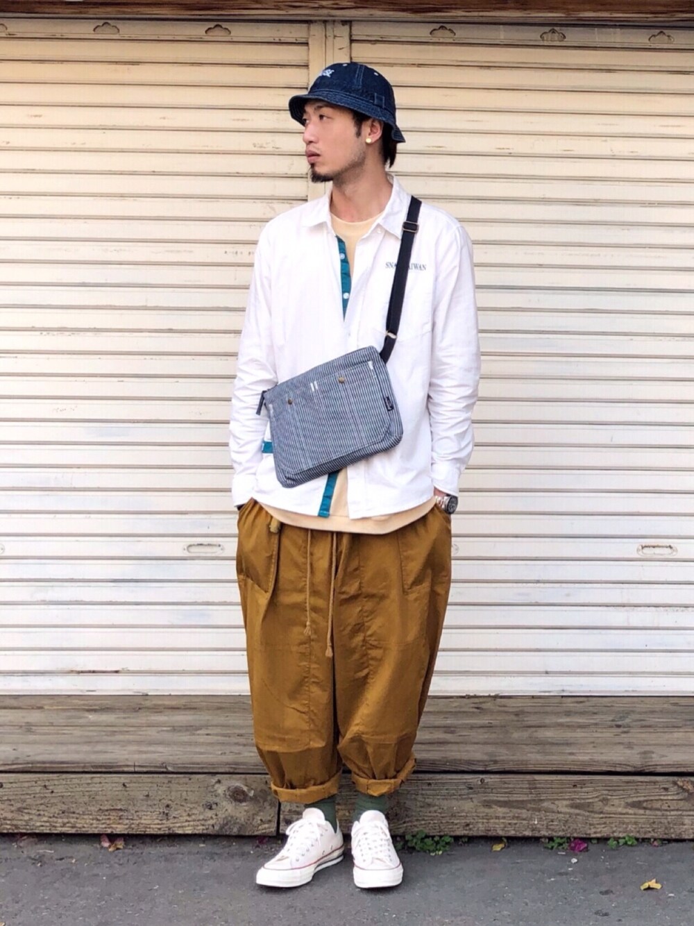 その他のショルダーバッグ、オレンジ系のチノパンツ、ホワイト系のシャツ/ブラウスを着用したメンズの春コーディネートの1枚目の写真