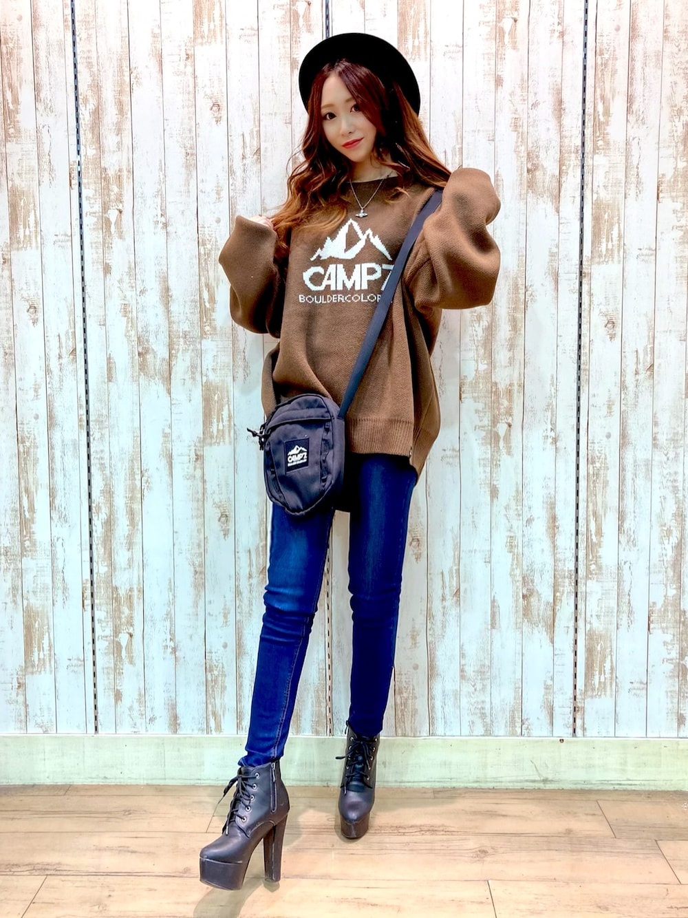 ブラウン系のニット/セーター、ブルー系のデニムパンツ、ブラック系のショルダーバッグを着用したレディースの秋コーディネートの1枚目の写真