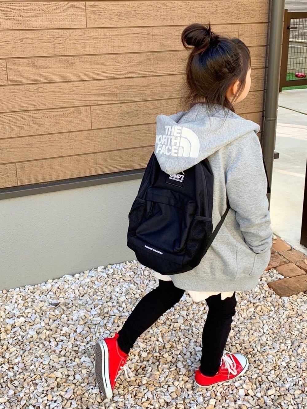 グレー系のパーカー、ブラック系のバックパック/リュック、ベージュ系のTシャツ/カットソーを着用したキッズの冬コーディネートの1枚目の写真