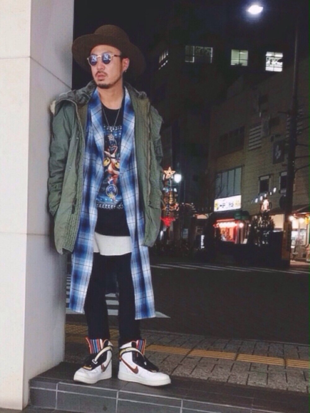 グリーン系のミリタリージャケット、ブルー系のシャツ/ブラウス、ブラック系のTシャツ/カットソーを着用したメンズの冬コーディネートの1枚目の写真
