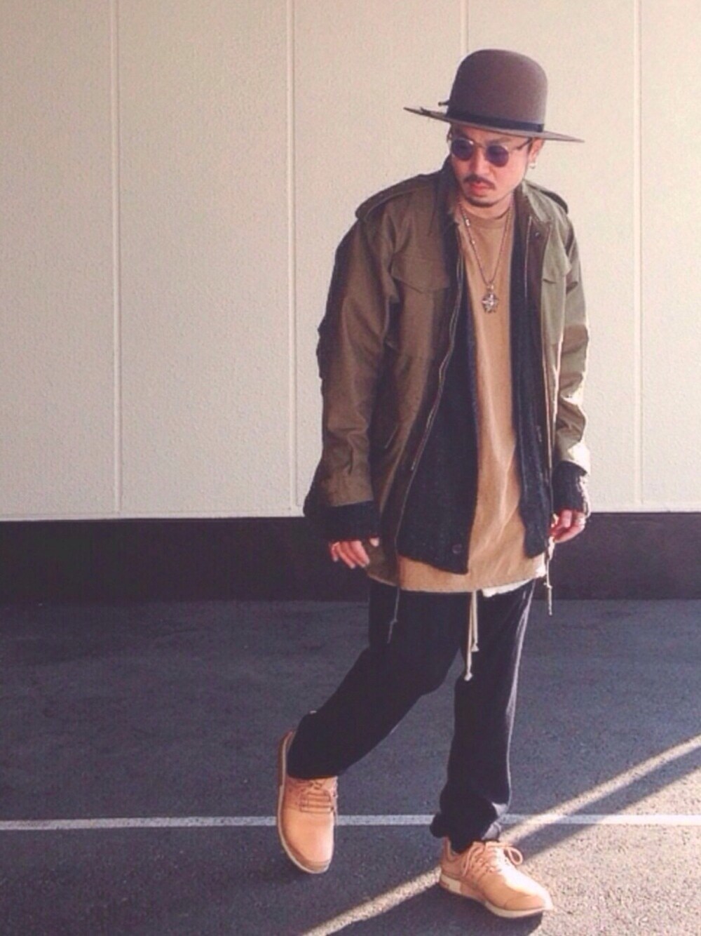 グリーン系のミリタリージャケット、ブラウン系のカーディガン/ボレロ、ベージュ系のTシャツ/カットソーを着用したメンズの冬コーディネートの1枚目の写真