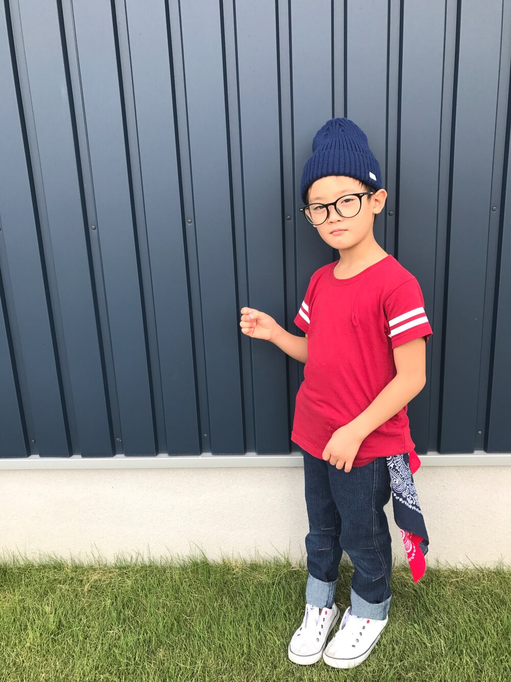 レッド系のTシャツ/カットソー、ブルー系のデニムパンツ、ホワイト系のスニーカーを着用したキッズの秋コーディネートの1枚目の写真