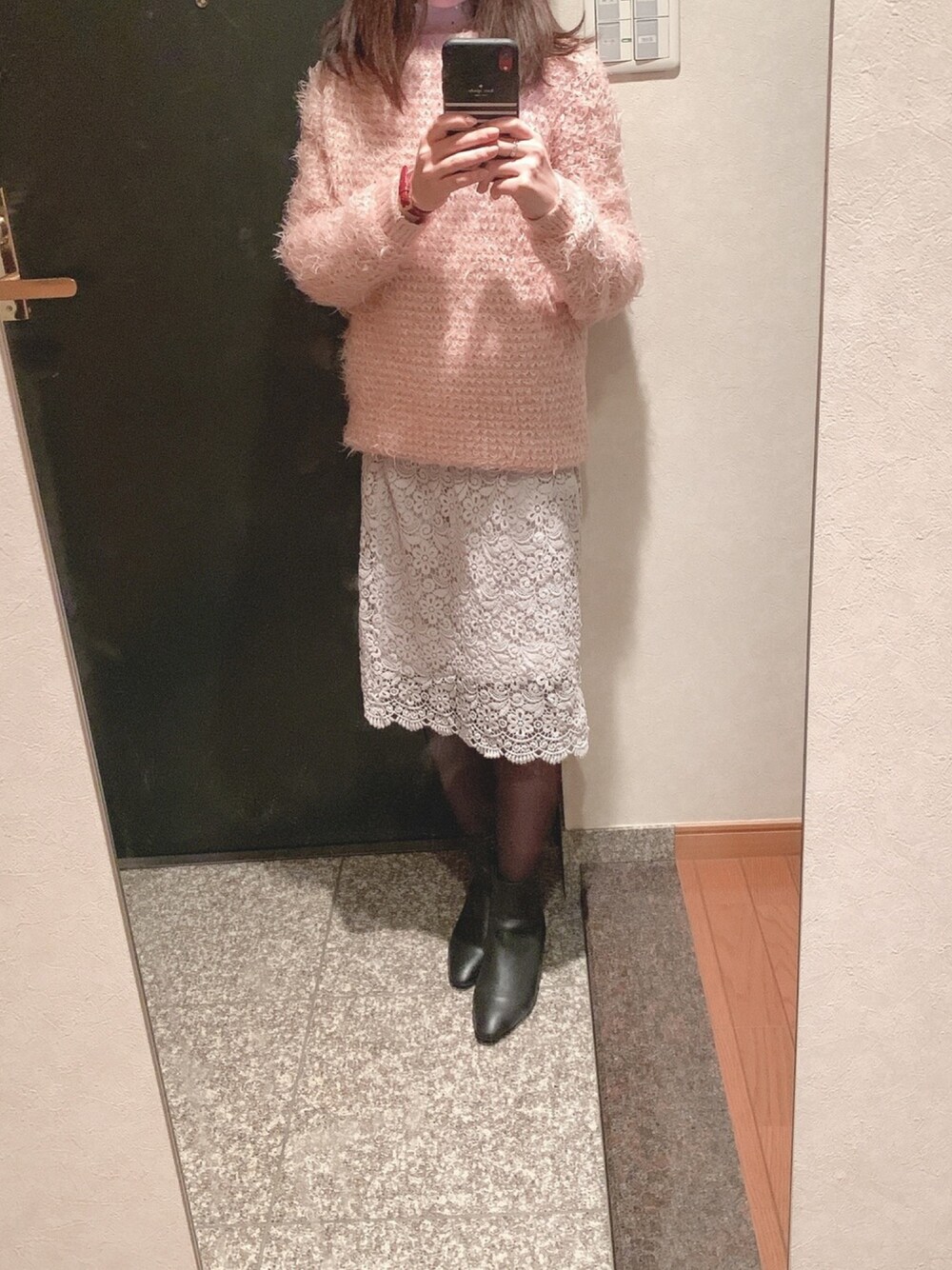 ピンク系のニット/セーター、グレー系のスカートを着用したレディースの冬コーディネートの1枚目の写真