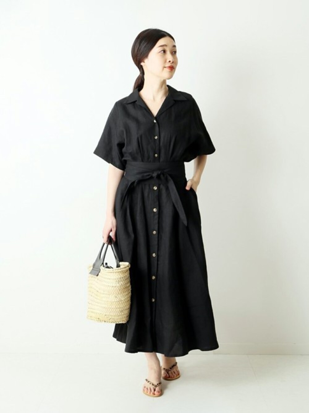 ブラック系のワンピースを着用したレディースの春コーディネートの1枚目の写真