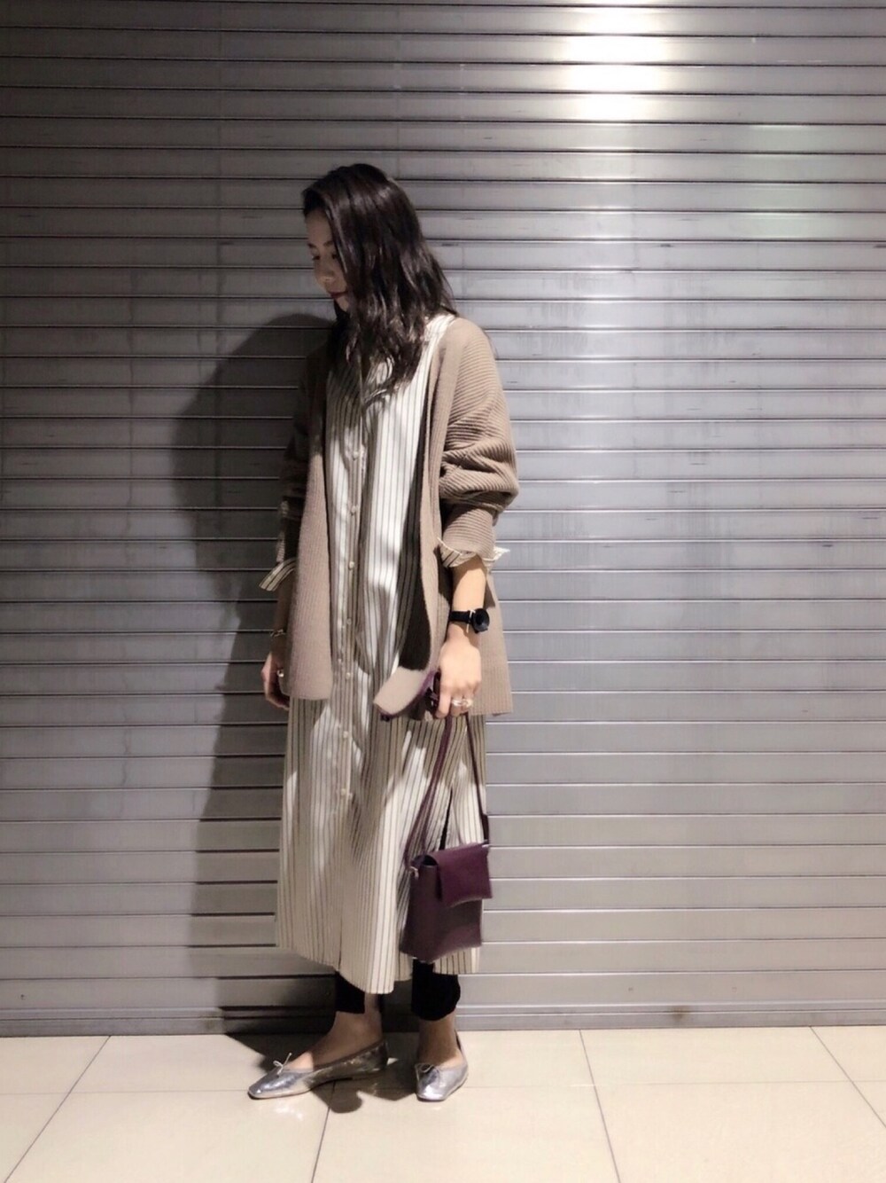 ベージュ系のカーディガン/ボレロ、ホワイト系のワンピース、シルバー系のバレエシューズを着用したレディースの秋コーディネートの1枚目の写真