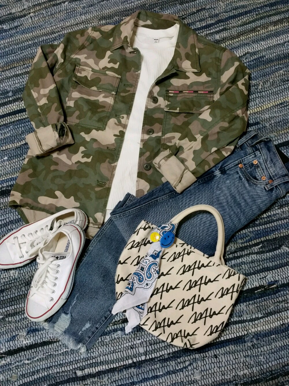 グリーン系のミリタリージャケット、ホワイト系のTシャツ/カットソー、ホワイト系のスニーカーを着用したレディースの春コーディネートの1枚目の写真