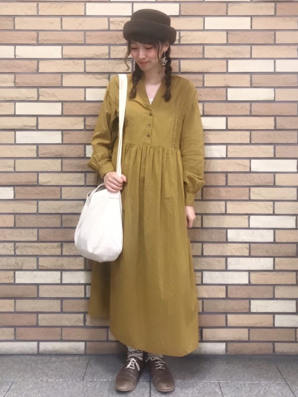 ブラウン系のTシャツ/カットソー、イエロー系のワンピース、ホワイト系のトートバッグを着用したレディースの秋コーディネートの1枚目の写真