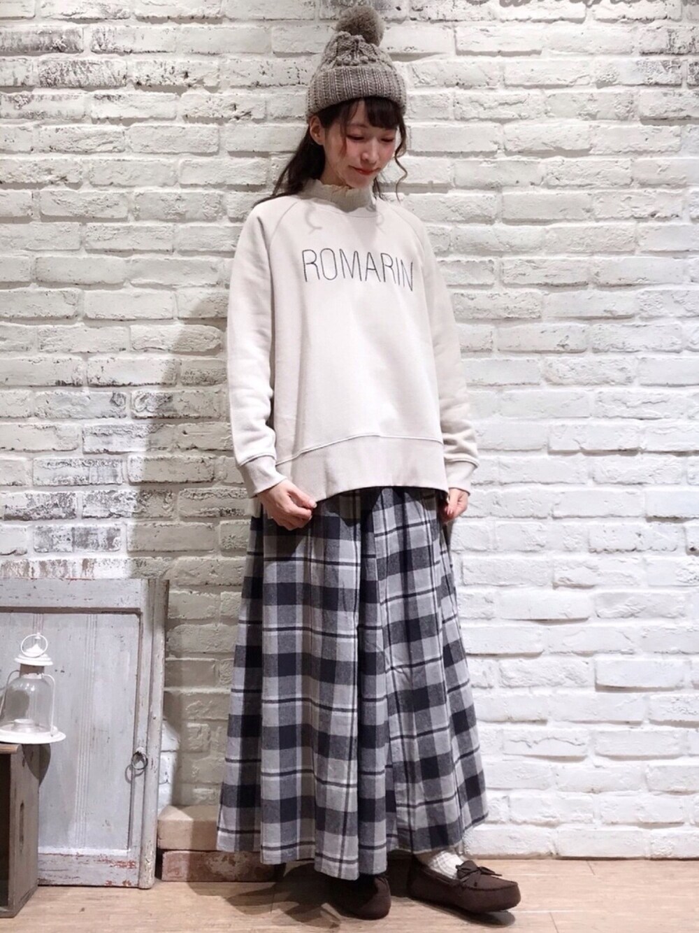 ホワイト系のシャツ/ブラウス、グレー系のスカート、ブラウン系のモカシン/デッキシューズを着用したレディースの冬コーディネートの1枚目の写真