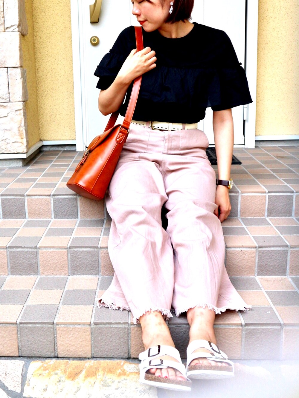 ピンク系のデニムパンツ、ホワイト系のサンダル、ブラック系のTシャツ/カットソーを着用したレディースの夏コーディネートの1枚目の写真