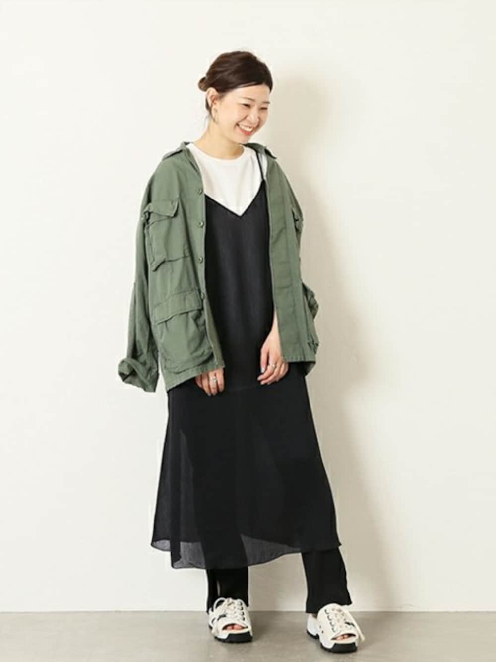 ブラック系のワンピース、ブラック系のその他パンツ、ホワイト系のTシャツ/カットソーを着用したレディースの春コーディネートの1枚目の写真