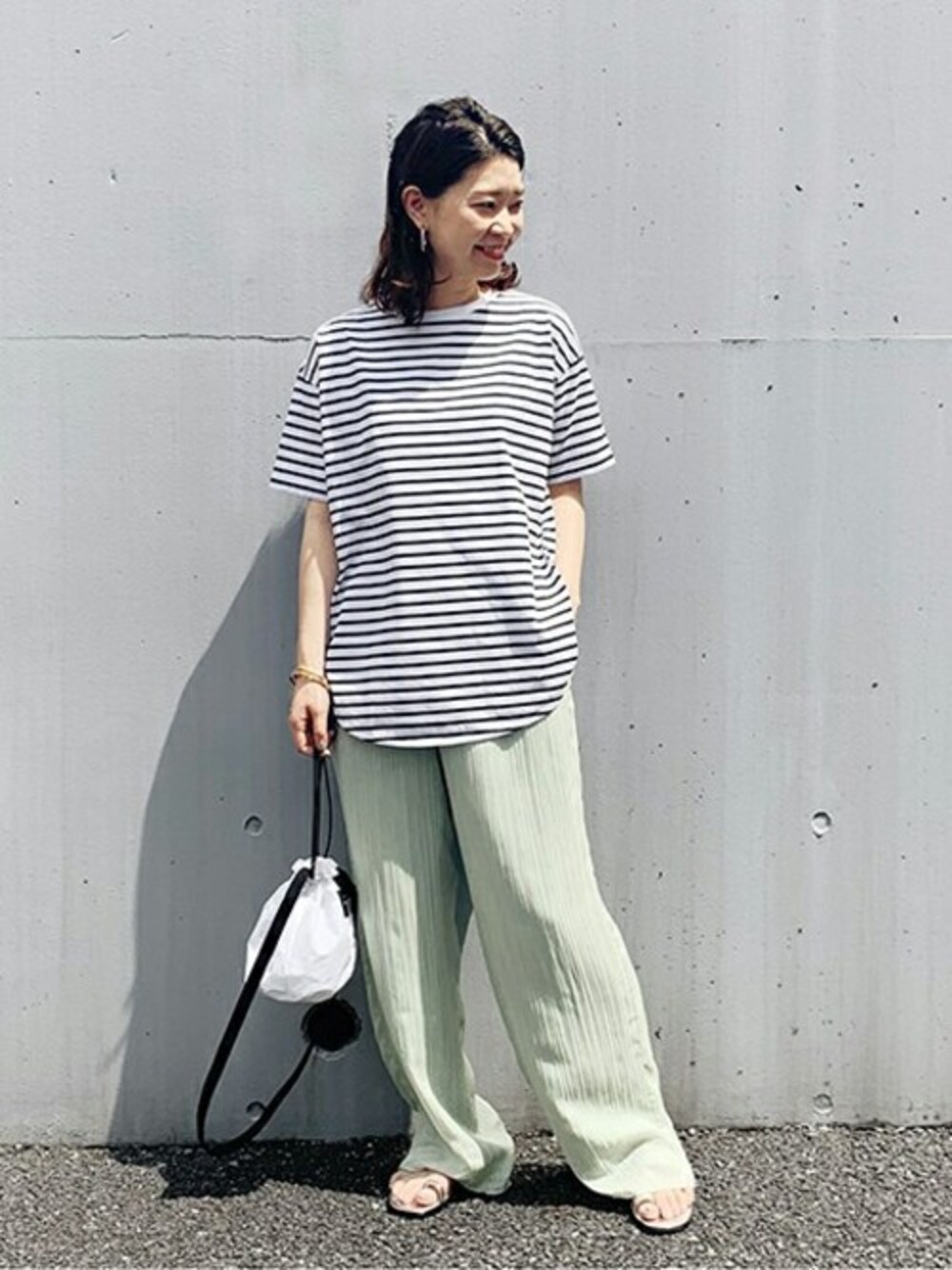 ホワイト系のTシャツ/カットソー、ホワイト系のショルダーバッグ、シルバー系のサンダルを着用したレディースの春コーディネートの1枚目の写真