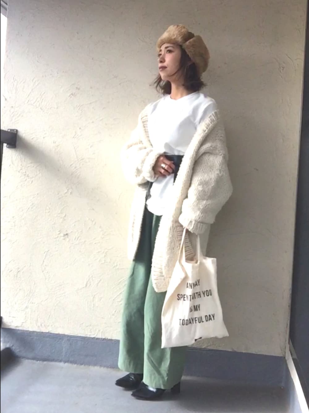 ホワイト系のTシャツ/カットソー、ホワイト系のカーディガン/ボレロ、ホワイト系のトートバッグを着用したレディースの冬コーディネートの1枚目の写真