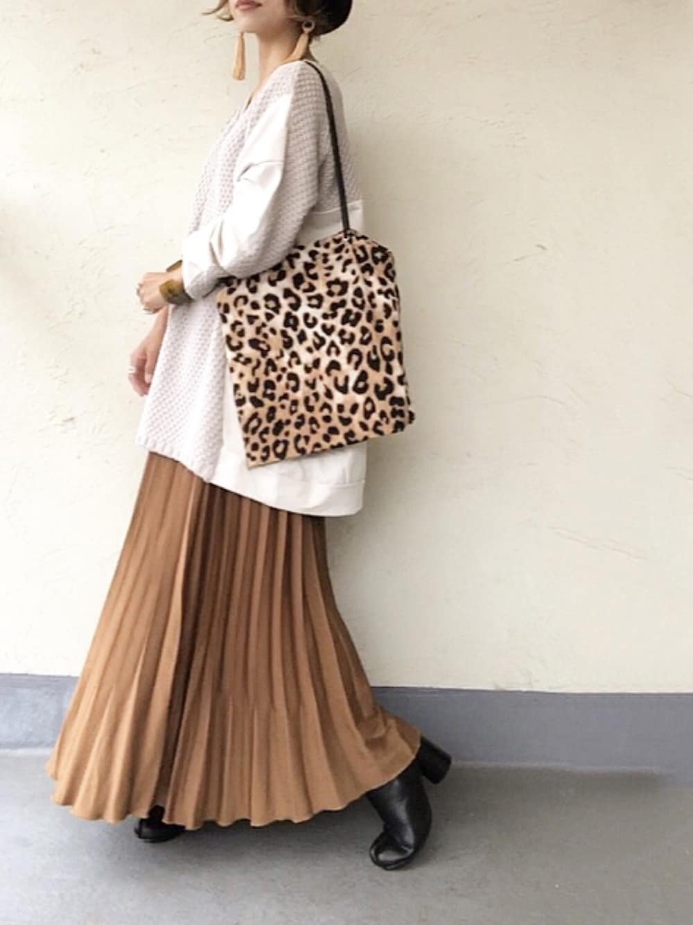 ベージュ系のニット/セーター、ベージュ系のトートバッグ、ブラウン系のスカートを着用したレディースの秋コーディネートの1枚目の写真