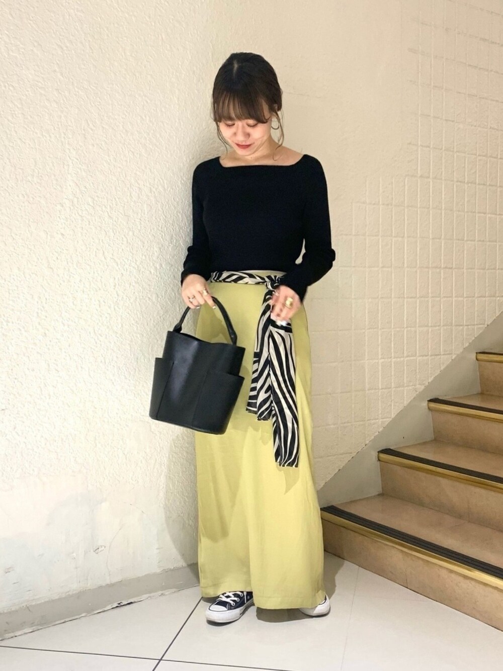 ブラック系のニット/セーター、グリーン系のスカート、ブラック系のショルダーバッグを着用したレディースの冬コーディネートの1枚目の写真