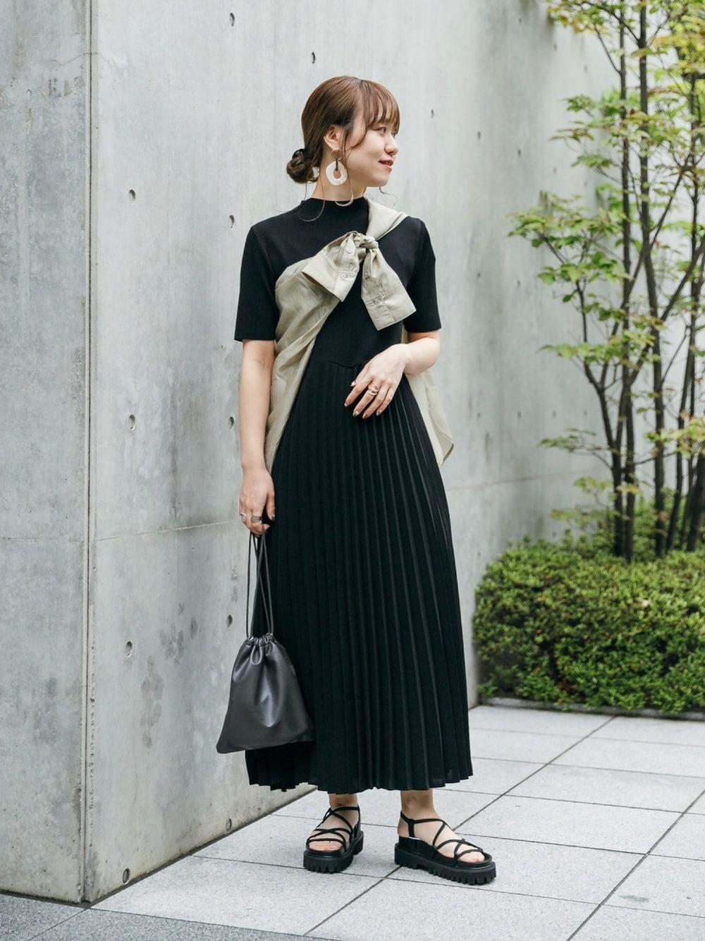 ブラック系のワンピース、グリーン系のシャツ/ブラウス、グレー系のバックパック/リュックを着用したレディースの春コーディネートの1枚目の写真