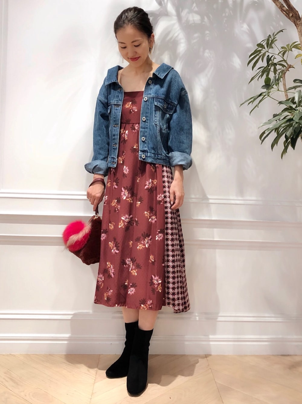 レッド系のワンピース、ブルー系のデニムジャケット、レッド系のトートバッグを着用したレディースの秋コーディネートの1枚目の写真