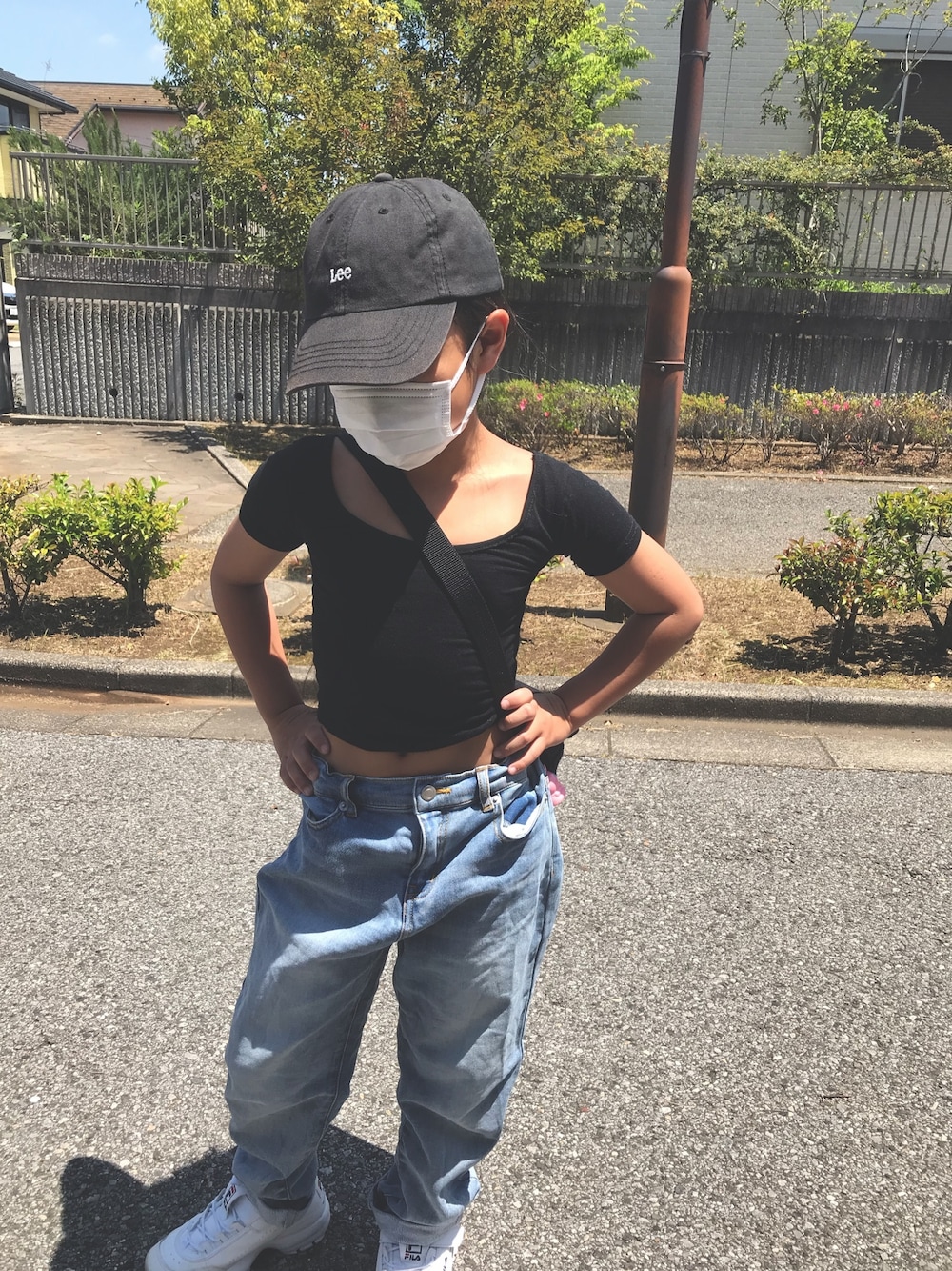 ブルー系のデニムパンツ、ホワイト系のスニーカー、ブラック系のキャップを着用したキッズの春コーディネートの1枚目の写真