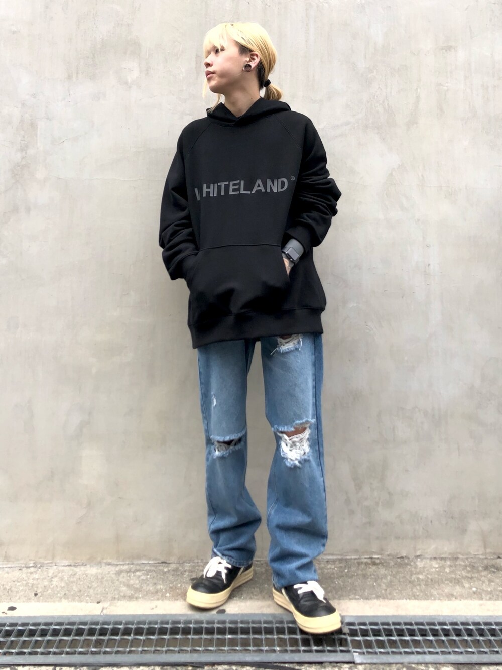 ブラック系のパーカー、ブルー系のデニムパンツ、ブルー系のデニムパンツを着用したメンズの春コーディネートの1枚目の写真