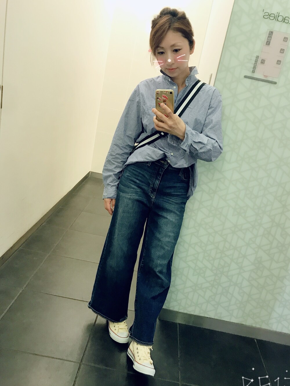 ブルー系のデニムパンツ、ベージュ系のスニーカーを着用したレディースの夏コーディネートの1枚目の写真