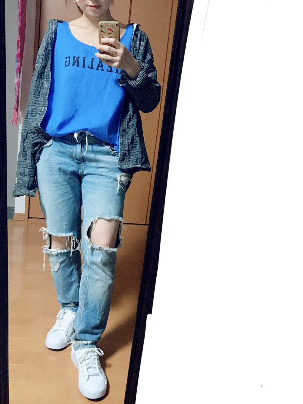 ホワイト系のスニーカー、ブルー系のデニムパンツ、グレー系のシャツ/ブラウスを着用したレディースの秋コーディネートの1枚目の写真