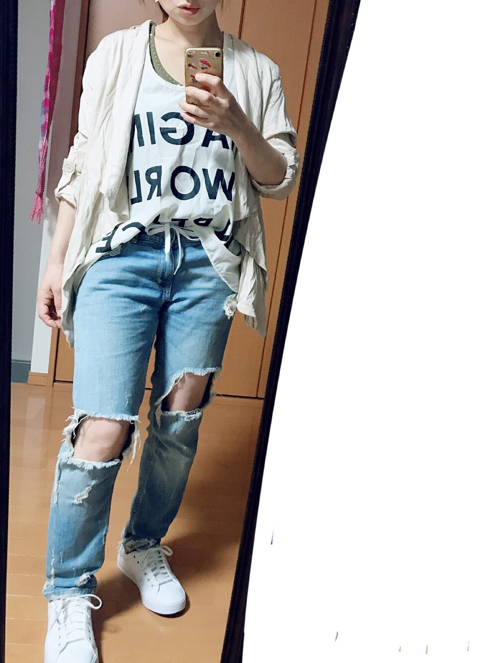 ホワイト系のスニーカー、ブルー系のデニムパンツ、ベージュ系のその他アウターを着用したレディースの秋コーディネートの1枚目の写真