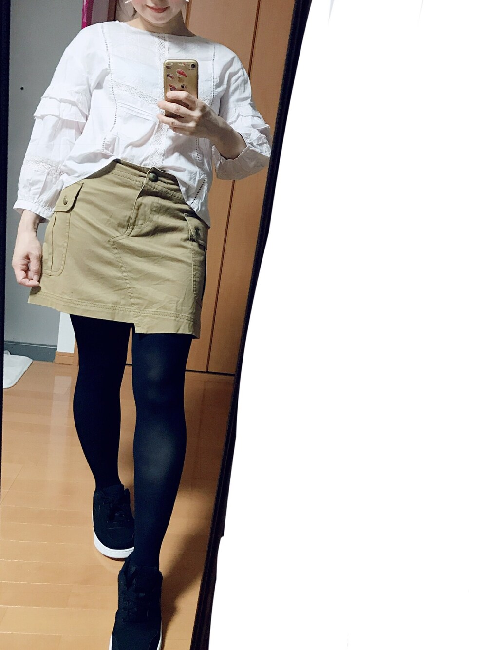 ブラック系のスニーカー、ブラウン系のデニムスカート、ピンク系のシャツ/ブラウスを着用したレディースの秋コーディネートの1枚目の写真