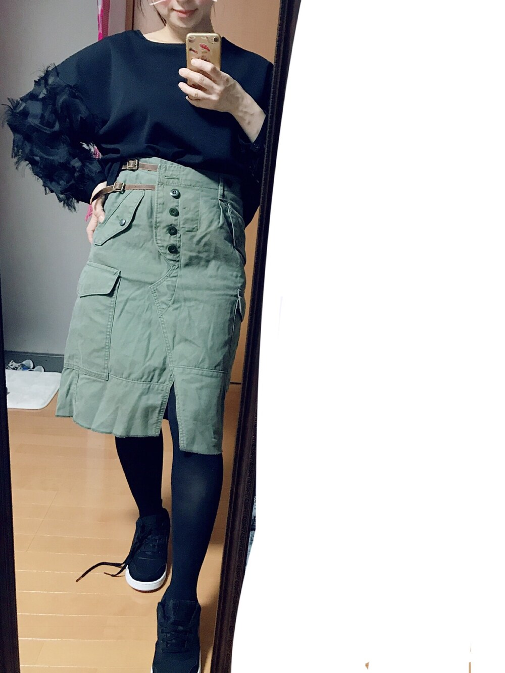 ブラック系のスニーカー、グリーン系のデニムスカートを着用したレディースの秋コーディネートの1枚目の写真