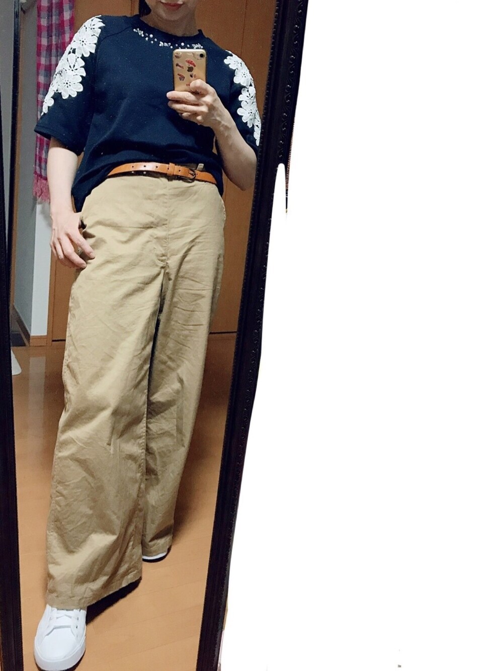 ホワイト系のスニーカー、ベージュ系のチノパンツを着用したレディースの秋コーディネートの1枚目の写真